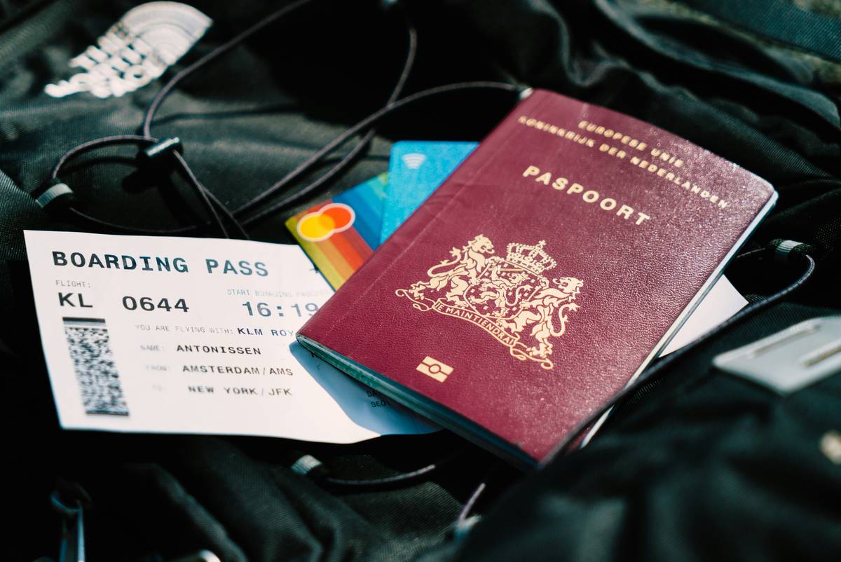 insure my ride motorcycle insurance: traveler inspecting a rental motorcycle with documents in hand